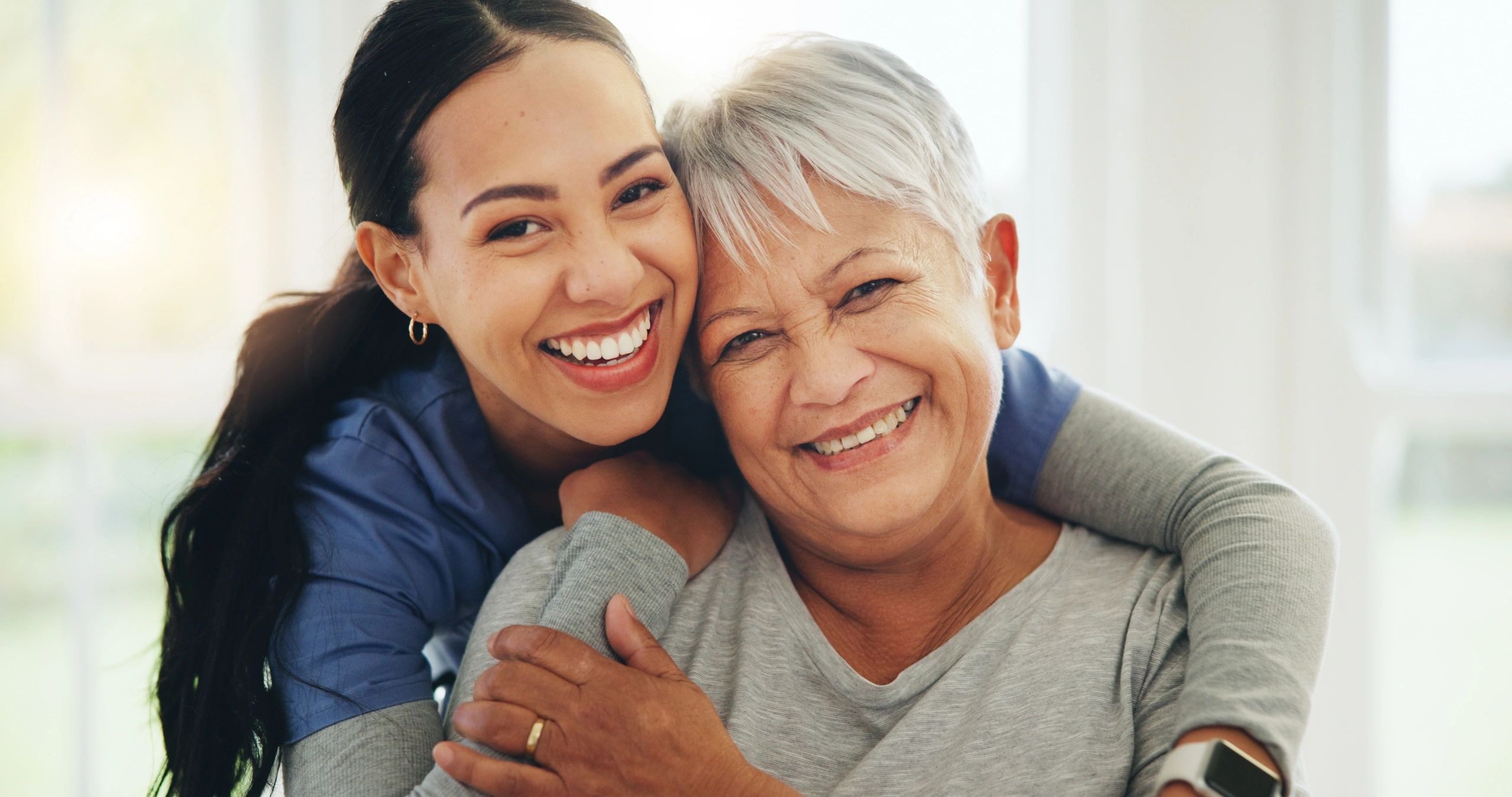 Two women smiling warmly — caregiver and client